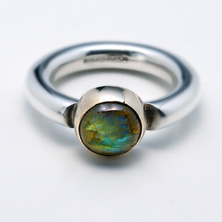 Heavy silver ring with a labradorite stone set in yellow gold 