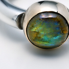 Heavy silver ring with a labradorite stone set in yellow gold 