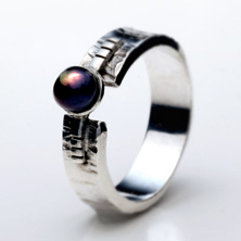 Textured silver band with black pearl set on a raised section of square wire 