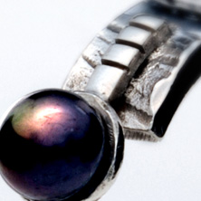 Textured silver band with black pearl set on a raised section of square wire 