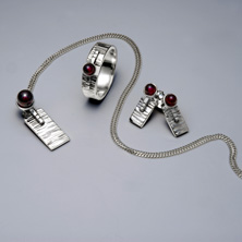 Silver and garnet set in a raised section of square wire 