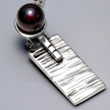 Silver and garnet set in a raised section of square wire 
