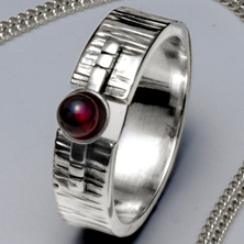Silver and garnet set in a raised section of square wire 