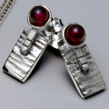 Silver and garnet set in a raised section of square wire 